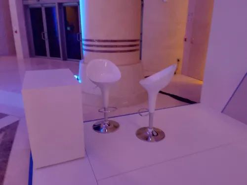 طاولة بيضاء مع كرسيين بار لون أبيض بتصميم عصري مناسبة للمؤتمرات والاجتماعات