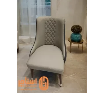 كرسي عصري بتصميم أنيق ومريح ومغطى بجلد فاخر باللون الرمادي،مع تفاصيل منجدة بنمط ماسي على الجزء الخلفي. للإيجار | استأجر
